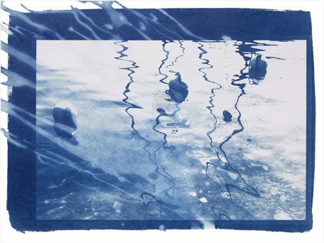 Blaue Wasseroberfläche mit gewellten Reflexionen und dunklen Schatten.