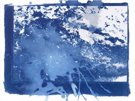 Abstrakte blaue Farbkleckse mit hellen Akzenten auf einer strukturierten Oberfläche.