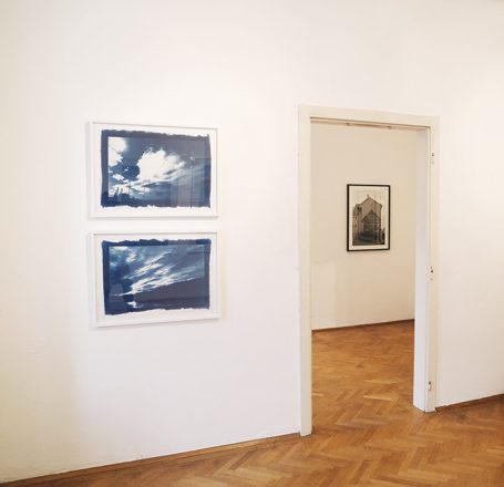 Zwei Bilder an der Wand und ein Blick durch eine Tür in einen weiteren Raum.