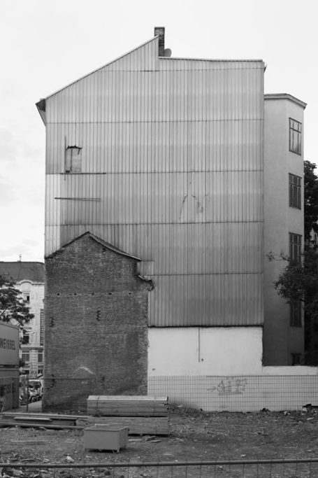 Zwei Gebäude mit unterschiedlichen Architekturstilen, eines modern, das andere historisch.