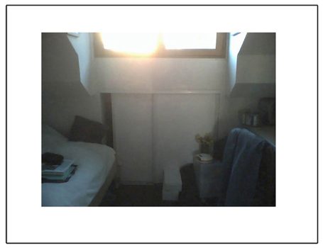 Helles Zimmer mit einem Bett, Fenster und einem kleinen Tisch.