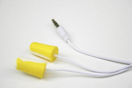Zwei gelbe Ohrstöpsel mit einem weißen Audiokabel und einem Klinkenstecker.