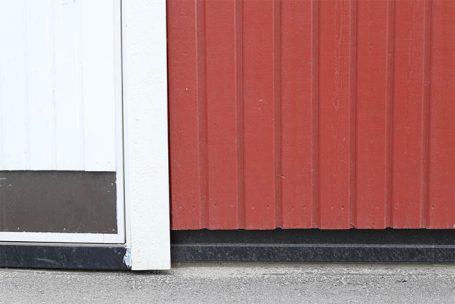 Weißer und roter Wandbereich mit vertikalen Streifen und leichtem Bodenrand.