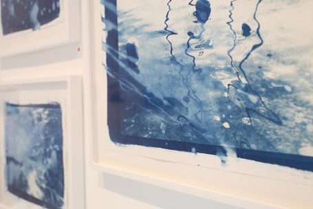 Abstrakte blaue Kunst mit verwischten Linien und Farbspritzern auf Papier.