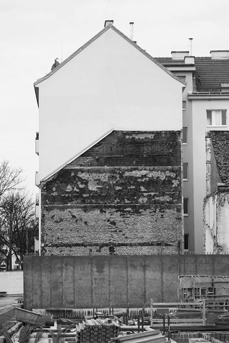 Renovations an einer Mauer mit freiliegendem Mauerwerk und schräg verlaufendem Dach.