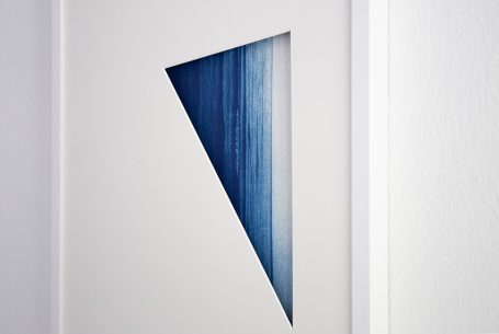 Dreieckige Öffnung in einer weißen Wand, mit blauer Farbverlauf.