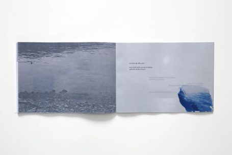 Offenes Buch mit grauem und blauem Design, Text und abstrakten Marmorierungen.