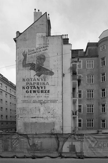 Wandgemälde eines Mannes mit erhobener Hand, schwarz-weiß, städtische Umgebung.