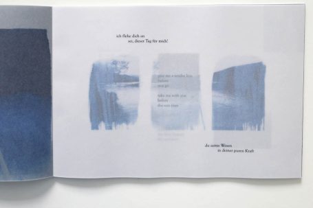 Blaues Farbspiel mit Textfragmenten auf hellem Hintergrund.