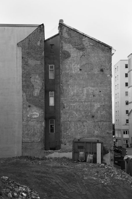 Zwei gegenüberliegende Gebäude mit einer schmalen, unvollendeten Fassade dazwischen.