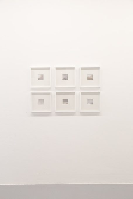 Sechs gerahmte Bilder an einer weißen Wand, mit verschiedenen minimalistischen Motiven.