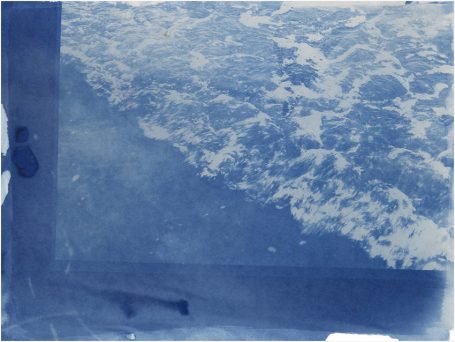 Wellen und spritzendes Wasser an einer Küste, in Blau- und Weißtönen.