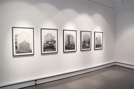Schwarz-weiße Fotografien von Gebäuden in einer Galerie.