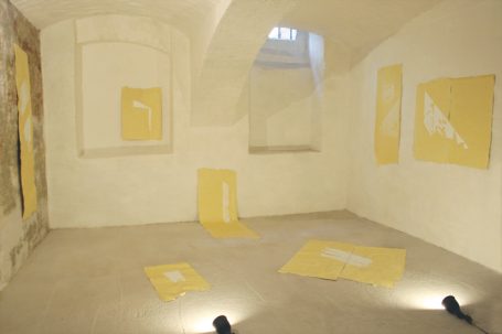 Leerer Raum mit gelben Kunstwerken an den Wänden und Boden. Schatten von Beleuchtung.