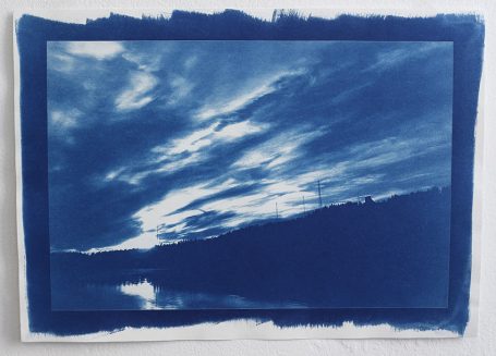 Himmel mit Wolken in verschiedenen Blautönen über einer Silhouette von Hügeln.