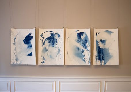 Abstrakte Kunstwerke in blauen Tönen, angeordnet in vier Rahmen an einer Wand.