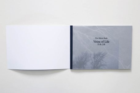 Ein aufgeschlagenes Buch mit einem grauen Cover und leeren Seiten.