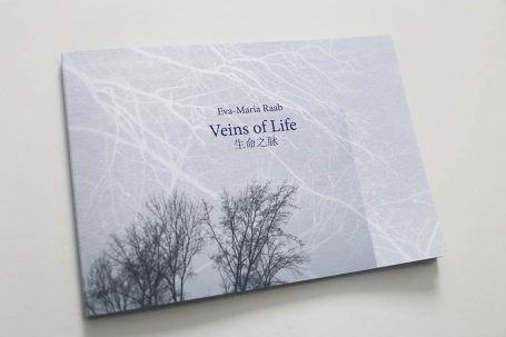 Ein Buchcover mit dem Titel "Veins of Life" und Silhouetten von Bäumen.