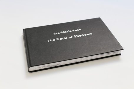 Schwarzes Buch mit dem Titel "The Book of Shadows" auf dem Cover.
