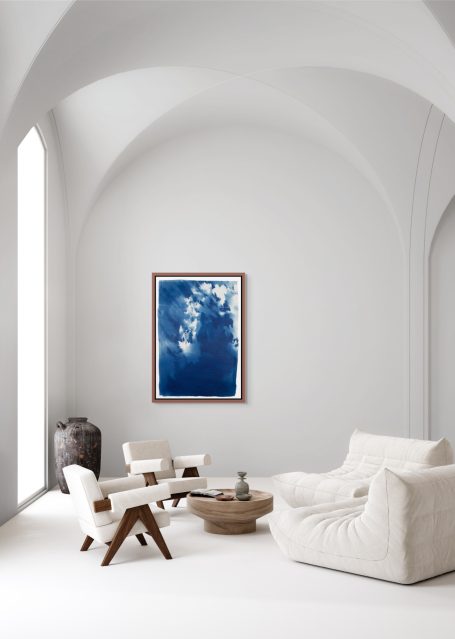 Helles Wohnzimmer mit weißen Möbeln, einem runden Tisch und einem blauen Wandbild.