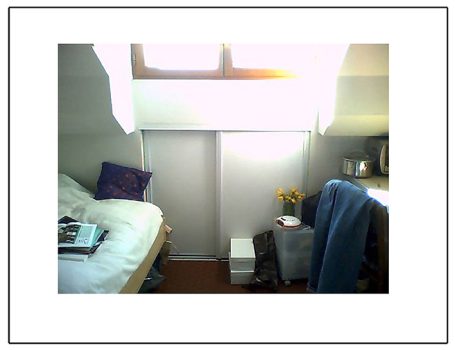 Ein gemütliches Schlafzimmer mit einem Bett, einem Fenster und einem Stuhl.