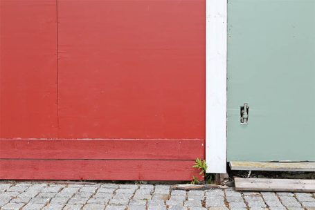 Rote und grüne Wand mit einem kleinen Pflanzenansatz und einem Schalter an der Ecke.