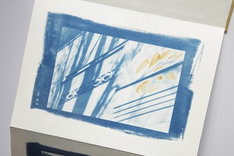 Blaue Druckgrafik mit geometrischen Mustern und Linien auf hellem Hintergrund.